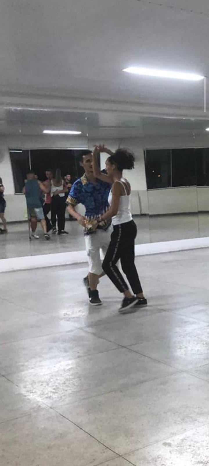 Nicchon dançando com parceira em sala de dança